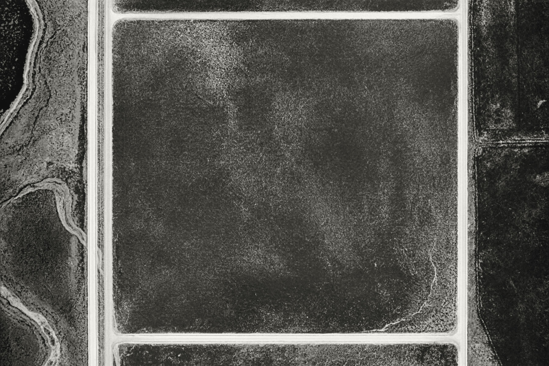 Plan-view aerial of one rectangular parcel of rangeland bounded by pale section-line roads — the same photograph shown for both parcels.