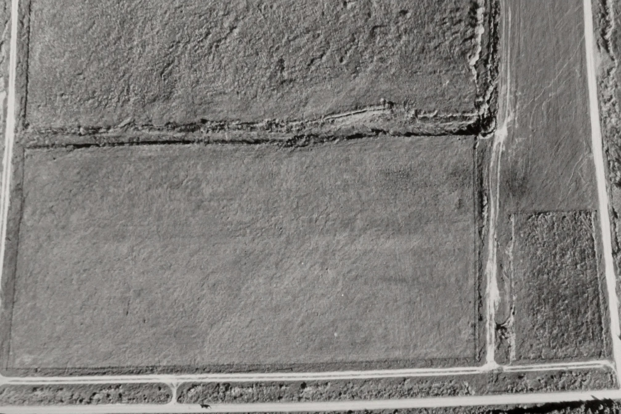 Plan-view aerial of an undeveloped tract bounded by section-line roads.
