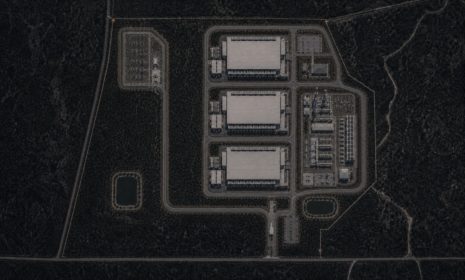 The same frame after vertical development: three long data halls standing on the central pads, a substation and switchyard east of them, a second switchyard on the north-west pad.